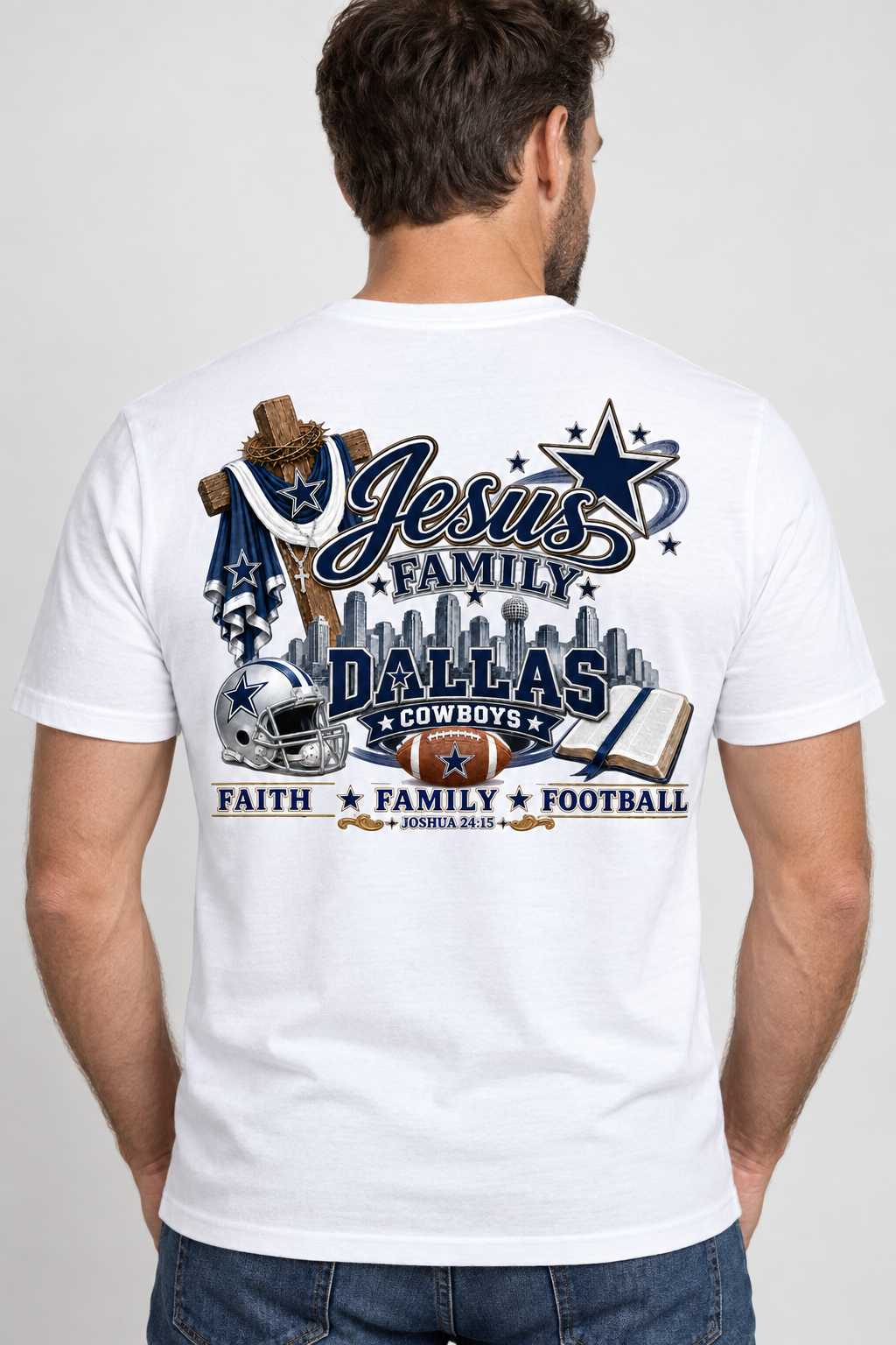 A man viewed from behind wearing a white graphic t-shirt with Dallas Cowboys football and Christian-themed designs, paired with blue jeans, against a light gray studio background.