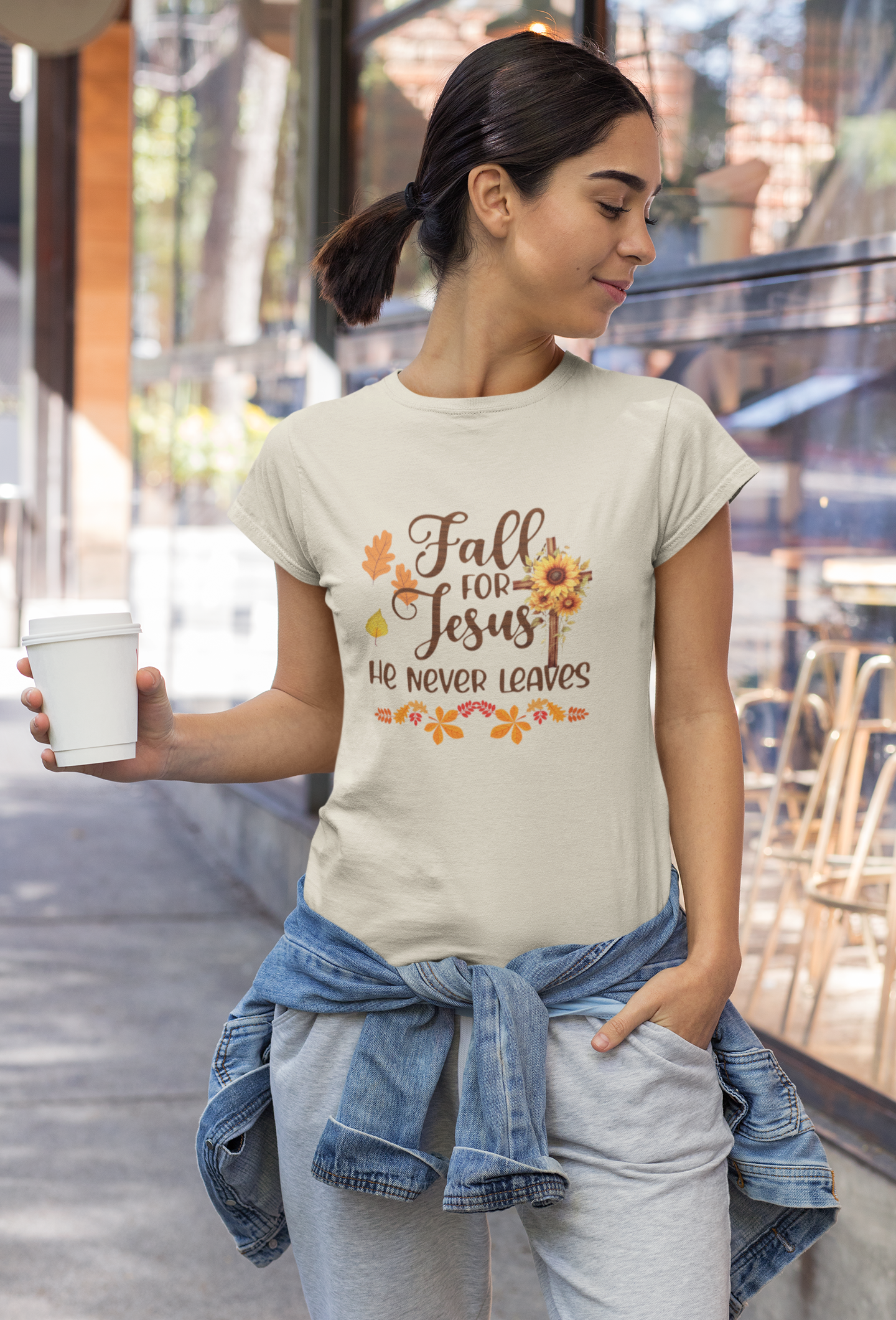 "Fall for Jesus He Never Leaves" hoodie in soft, premium fabric with elegant script design, available in various colors and sizes. Perfect for cozy fall days.